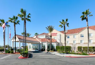 a hotel with palm trees in a parking lot at Hilton Garden Inn Irvine East/Lake Forest in Foothill Ranch
