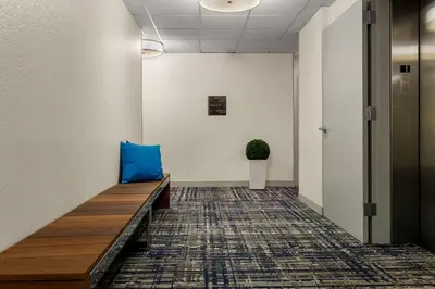 a hallway with a blue pillow on a bench at Sonesta Simply Suites Irvine East Foothill in Lake Forest