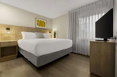 a bedroom with a large bed and a flat screen tv at Sonesta Simply Suites Irvine East Foothill in Lake Forest