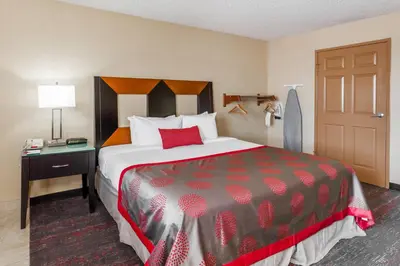 a hotel room with a large bed and a door at Ramada by Wyndham San Diego National City in National City