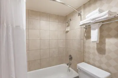 a bathroom with a white toilet and a shower at Ramada by Wyndham San Diego National City in National City