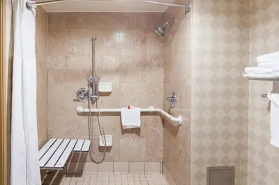 a bathroom with a shower with a toilet at Ramada by Wyndham San Diego National City in National City
