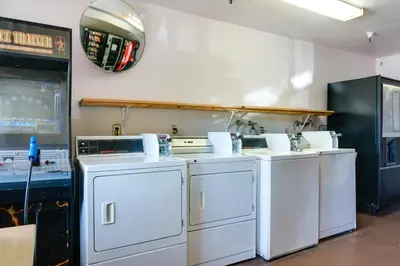 a laundry room with four washes and a mirror on the wall at Heritage Inn La Mesa in La Mesa