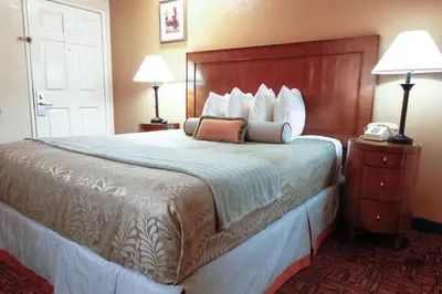a hotel room with a bed and a telephone at Heritage Inn La Mesa in La Mesa