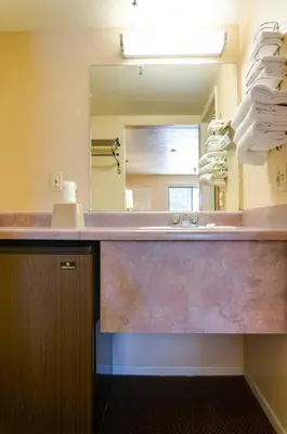 a bathroom counter with a sink and a mirror at Heritage Inn La Mesa in La Mesa