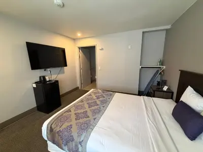 a hotel room with a bed and a flat screen tv at Heritage Inn San Diego in San Diego