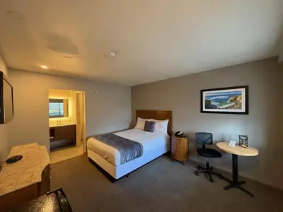 a hotel room with a bed and a table at Heritage Inn San Diego in San Diego