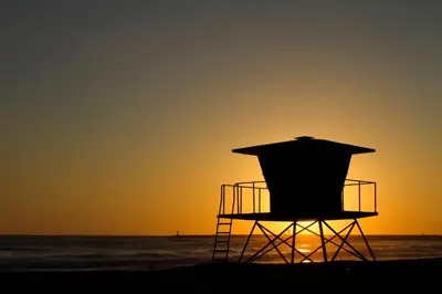 a lifeguard chair at the beach at sunset at Holiday Inn Oceanside Marina Camp Pendleton by IHG in Oceanside