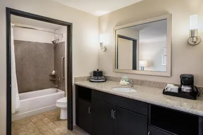 a bathroom with a sink and a toilet and a mirror at Holiday Inn Oceanside Marina Camp Pendleton by IHG in Oceanside