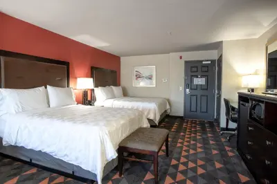 a hotel room with two beds and a chair at Holiday Inn Oceanside Marina Camp Pendleton by IHG in Oceanside