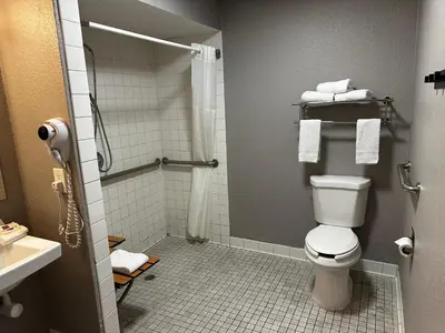 a bathroom with a toilet and a shower with towels at Motel 6-San Diego, CA - Hotel Circle - Mission Valley in San Diego