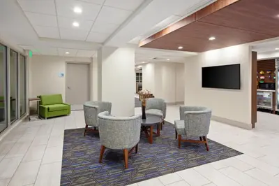 a waiting room with a table and chairs and a tv at Holiday Inn Express Hotel & Suites San Diego-Escondido by IHG in Escondido