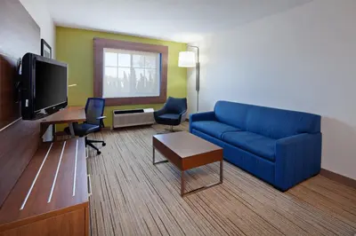 a living room with a blue couch and a tv at Holiday Inn Express Hotel & Suites San Diego-Escondido by IHG in Escondido