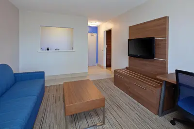 a living room with a blue couch and a flat screen tv at Holiday Inn Express Hotel & Suites San Diego-Escondido by IHG in Escondido