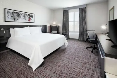 a hotel room with a large white bed and a desk at Hilton Garden Inn Irvine Spectrum Lake Forest in Lake Forest