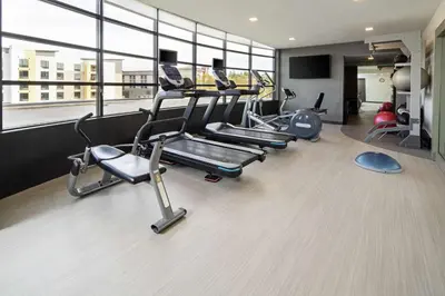 a gym with several cardio machines in a room with windows at Hilton Garden Inn Irvine Spectrum Lake Forest in Lake Forest