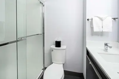 a bathroom with a toilet and a glass shower at Hilton Garden Inn Irvine Spectrum Lake Forest in Lake Forest