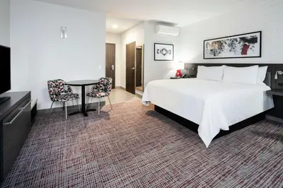 a hotel room with a large bed and a table at Hilton Garden Inn Irvine Spectrum Lake Forest in Lake Forest