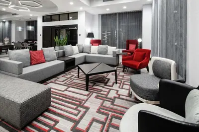 a living room with couches and red chairs at Hilton Garden Inn Irvine Spectrum Lake Forest in Lake Forest