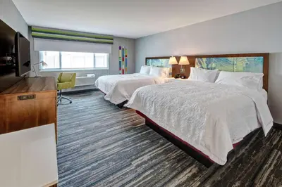 a hotel room with two beds and a flat screen tv at Hampton by Hilton Encinitas-Cardiff Encinitas, CA near Del Mar in Encinitas