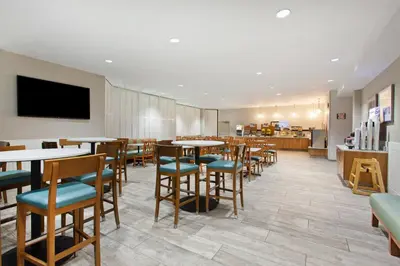 a dining room with tables and chairs and a cafeteria at Holiday Inn Express Newport Beach by IHG in Newport Beach