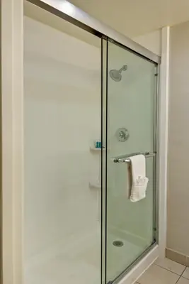 a shower with a glass door in a bathroom at Holiday Inn Express Newport Beach by IHG in Newport Beach