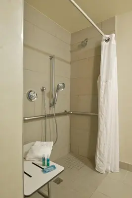a bathroom with a shower with a shower curtain at Holiday Inn Express Newport Beach by IHG in Newport Beach