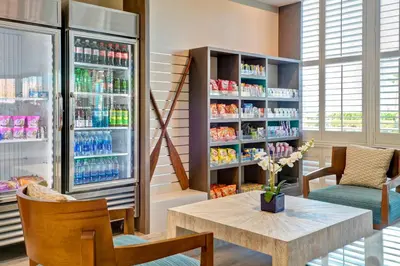 a room with a refrigerator and a table and chairs at Holiday Inn Express Newport Beach by IHG in Newport Beach