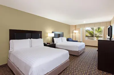 a hotel room with two beds and a television at Holiday Inn Express Newport Beach by IHG in Newport Beach