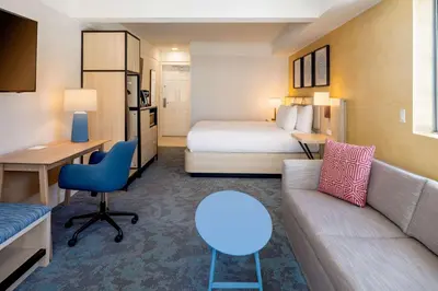 a hotel room with a couch and a bed at Hilton Garden Inn Dana Point Doheny Beach in Dana Point