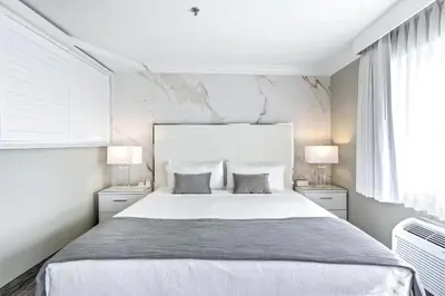 a white bedroom with a large bed and two lamps at The Volare, an Ascend Collection Hotel in San Clemente