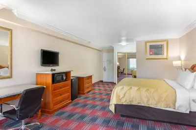 a hotel room with a bed and a desk and a television at Quality Inn & Suites Oceanside Near Camp Pendleton in Oceanside