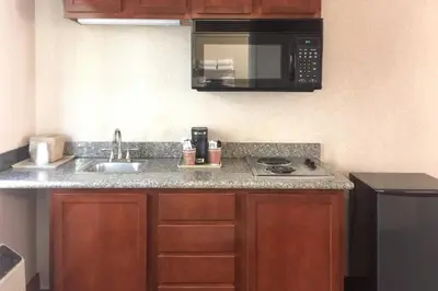 a kitchen with a sink and a microwave at Quality Inn & Suites Oceanside Near Camp Pendleton in Oceanside