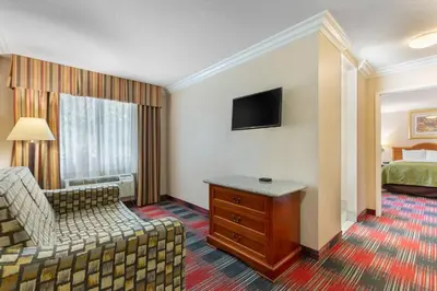 a hotel room with a bedroom with a bed and a couch at Quality Inn & Suites Oceanside Near Camp Pendleton in Oceanside