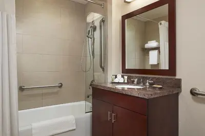 a bathroom with a sink and a shower and a mirror at Marbrisa Carlsbad Resort in Carlsbad