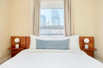a bedroom with a large white bed with a window at Kasa Gaslamp Quarter San Diego in San Diego