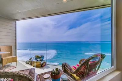 a room with a large window with a view of the ocean at Work Friendly Oceanfront SURF25 Condo in Solana Beach