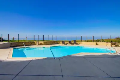 a swimming pool with a view of the ocean at Work Friendly Oceanfront SURF25 Condo in Solana Beach
