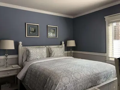 a bedroom with a large bed with blue walls at Kate Stanton Inn in Encinitas