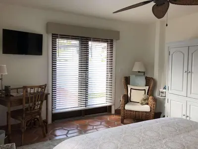 a bedroom with a bed and a chair and a window at Kate Stanton Inn in Encinitas