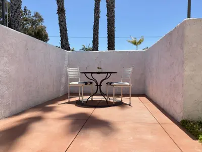 two chairs and a table in front of a wall at Kate Stanton Inn in Encinitas
