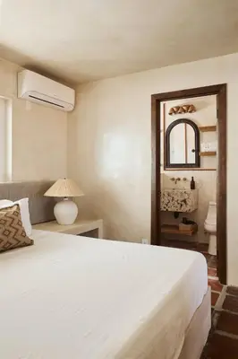 a bedroom with a white bed and a mirror at Los Bungalows in Imperial Beach