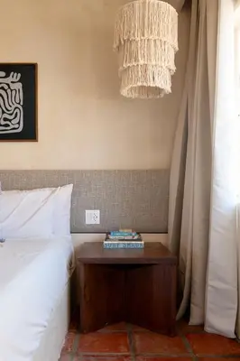 a bedroom with a bed and a nightstand next to a table at Los Bungalows in Imperial Beach