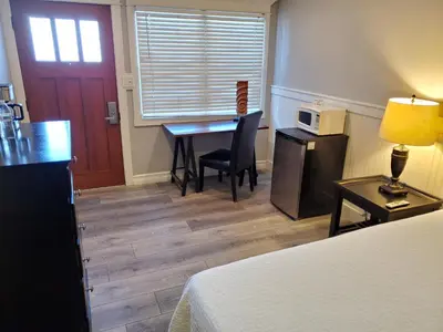 a hotel room with a desk and a bed at Coronado Inn in San Diego