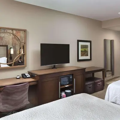 a hotel room with a desk with a flat screen tv at Hampton Inn & Suites Murrieta Temecula in Murrieta