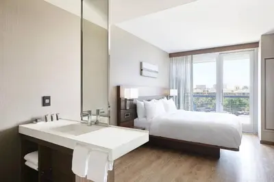 a hotel room with a bed and a sink at AC Hotel by Marriott Irvine in Irvine