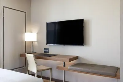 a hotel room with a desk and a flat screen tv at AC Hotel by Marriott Irvine in Irvine