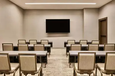 a conference room with tables and chairs and a flat screen tv at AC Hotel by Marriott Irvine in Irvine