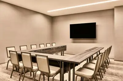 a conference room with a table and chairs and a flat screen tv at AC Hotel by Marriott Irvine in Irvine