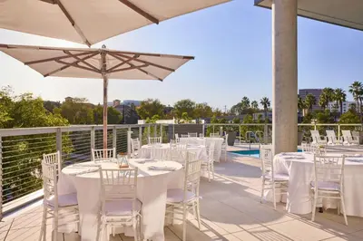 a patio with tables and chairs and an umbrella at AC Hotel by Marriott Irvine in Irvine